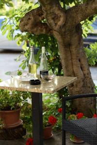Studio apartman MARINA في فوديس: زجاجتان من النبيذ على طاولة بجوار شجرة