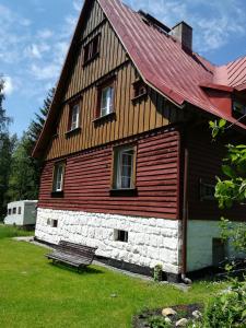 a wooden house with a bench in front of it at Leśna Polana in Lasowka +10 photos