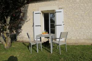Le Verger des Hirondelles Chambres hôtes في Bournan: طاولة و كرسيين امام المبنى
