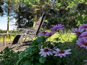 Zwei Stühle und ein Tisch und ein paar lila Blumen. in der Unterkunft 6 person holiday home in Nyk bing M in Hesselbjerg