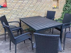 een zwarte tafel en stoelen en een tafel en stoelen bij 6 person holiday home in Nyk bing M in Hesselbjerg