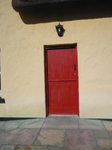 a red door on the side of a building at Inspiration Lodge in Anascaul