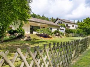 a wooden fence in front of a house at Idyllic Bungalow in Feusdorf with by the Forest in Feusdorf