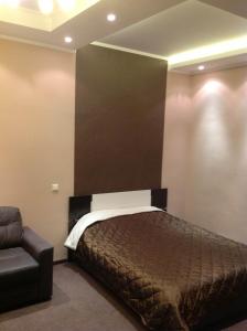 1 dormitorio con 1 cama y 1 silla en una habitación en City Apartments Taganskaya, en Moscú