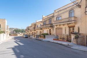 uma rua vazia em frente a um edifício em Cloud 9 Residence em Għajnsielem