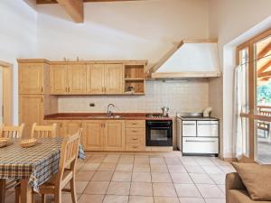 une cuisine avec des placards en bois et une table dans l'établissement Belvilla by OYO Il melo bianco, à Caldes
