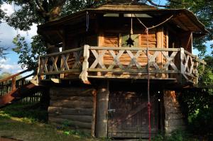 a log cabin with a porch and a deck at Agroturystyka Smolnikowe Klimaty - Sauna&Jacuzzi in Smolnik