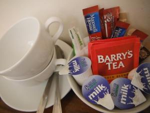 a plate with cups and toothbrushes and a cup and books at Inspiration Lodge in Anascaul