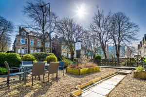 a patio with a table and chairs in a park at Fountains Guest House - Harrogate Stays in Harrogate