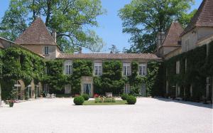 ein großes Haus mit einem Innenhof davor in der Unterkunft "Gite d'Ici et d'Ailleurs 1&2 Dépendance dans propriété et maison indépendante in Saint-Morillon