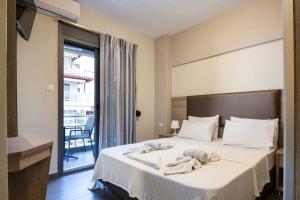 een hotelkamer met een bed met handdoeken erop bij Sole A Mare in Neos Marmaras