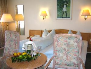 Habitación de hotel con cama, mesa y sillas en Landhotel Sonneneck - Breuna im Naturpark, en Breuna