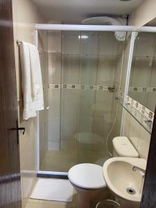 y baño con ducha, aseo y lavamanos. en Flat Camorim em Angra dos Reis/RJ. en Angra dos Reis
