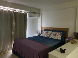 um quarto com uma cama e uma janela em Flat Camorim em Angra dos Reis/RJ. em Angra dos Reis