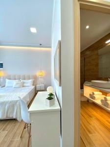a bedroom with a white bed and a bathroom at Elia Room & Garden in Kontokali