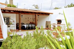 a garden with a house with a patio at Santiago Residence Guest House in Santiago do Cacém