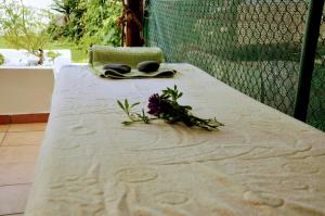 a table with a towel and some flowers on it at Santiago Residence Guest House in Santiago do Cacém