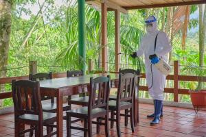 a man in a costume standing in front of a table at Hosteria El Paraiso de las Orquideas in Archidona