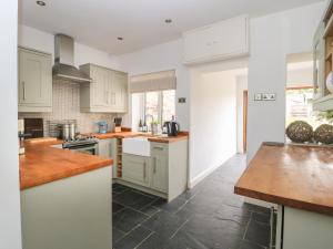a kitchen with white cabinets and a tile floor at Griff Lodge in York