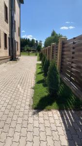 a brick road with a fence and some trees at Guest house Shchedrino in Yaroslavl