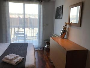 een slaapkamer met een bed, een dressoir en een balkon bij Descanso Termal in Ourense