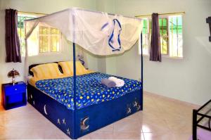 a blue and white bed with a blue canopy on top of it at Blue Lady Rooms B&B in Jarabacoa