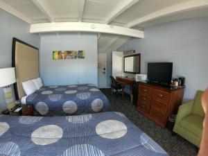 a hotel room with two beds and a desk at Copper Lantern Motor Lodge in West Brookfield