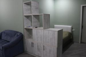 um armário de madeira num quarto com uma cama e uma cadeira em Batumi Loves you Apartment em Batumi