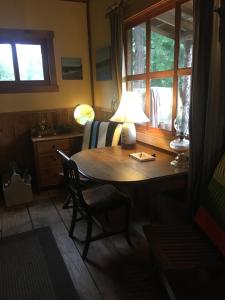 a room with a table with a lamp and a chair at Maple Heart Ranch in Shawnigan Lake
