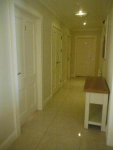 an empty hallway with a table and a door at Inspiration Lodge in Anascaul