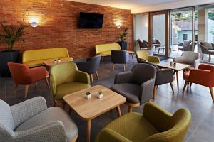 a restaurant with chairs and tables and a brick wall at Hotel Adalbert Szent Tamás ház in Esztergom