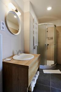 a bathroom with a sink and a shower at Hotel Adalbert Szent Tamás ház in Esztergom