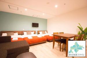 Pokój z łóżkiem, stołem i kanapą w obiekcie SEVEN Building / Vacation STAY 4948 w mieście Asahikawa