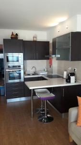 a kitchen with a table and a purple stool at Sunset Beach in Costa da Caparica