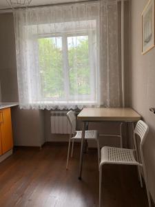 ケメロヴォにあるApartment on Tukchachevskogo 2の窓のある部屋(テーブル、椅子付)