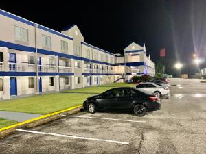 a black car parked in a parking lot in front of a building at Sunrise Extended Stay Hotel in Montgomery