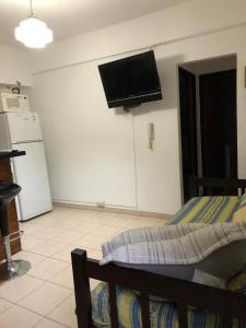 1 dormitorio con 1 cama y TV en la pared en Bellas Artes en La Plata