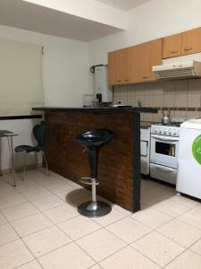 a kitchen with a black counter and a stool in it at Bellas Artes in La Plata