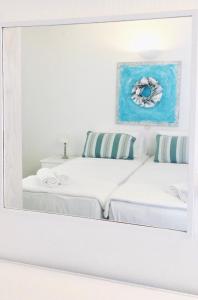 two beds in a room with a mirror at Salty Houses in Kalo Livadi
