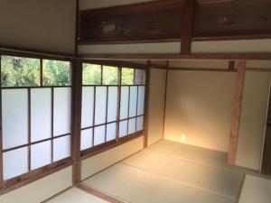 une pièce vide avec fenêtres dans un bâtiment dans l'établissement ゲストハウス三軒家, à Shirahama