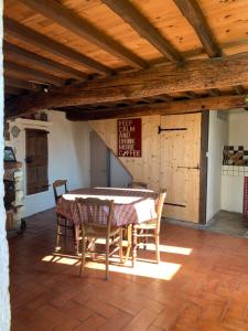 a dining room with a table and chairs on a patio at La Bugadière in Salles-sous-Bois