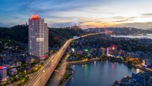 a city with a bridge over a body of water at Ramada Hotel & Suites by Wyndham Halong Bay View in Ha Long