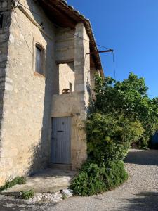 a stone building with a door on the side of it at La Bugadière in Salles-sous-Bois