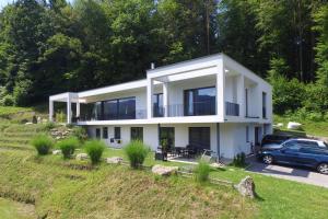 a white house with a car parked in front of it at Appartement Belvedere in Keutschach am See