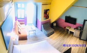 a living room with a couch and a tv at Sea Forest Homestay in Suao