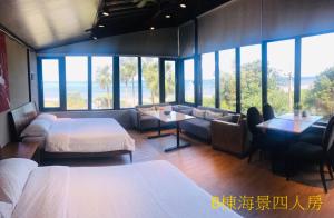 Habitación con 2 camas, sofá y ventanas en Sea Forest Homestay, en Suao