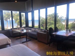 Habitación de hotel con sofá, mesa y ventanas en Sea Forest Homestay, en Suao