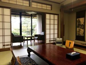 a living room with a wooden table and chairs at Iwamuro Slow Hostel in Niigata