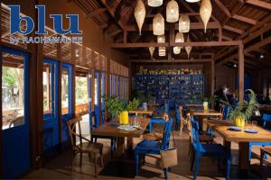un restaurante con mesas de madera y sillas azules en Rachawadee Resort & Hotel, en Khon Kaen