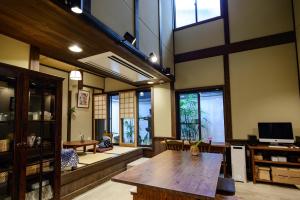 京都市にある京町家 楽遊 堀川五条の木製テーブル、一部の窓が備わる広い客室です。